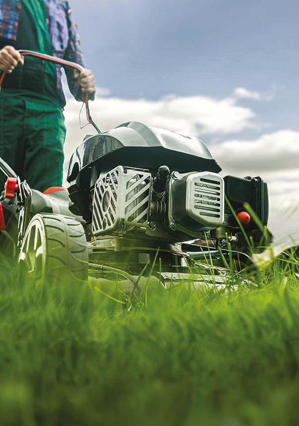 Man with lawn mower mowing the lawn